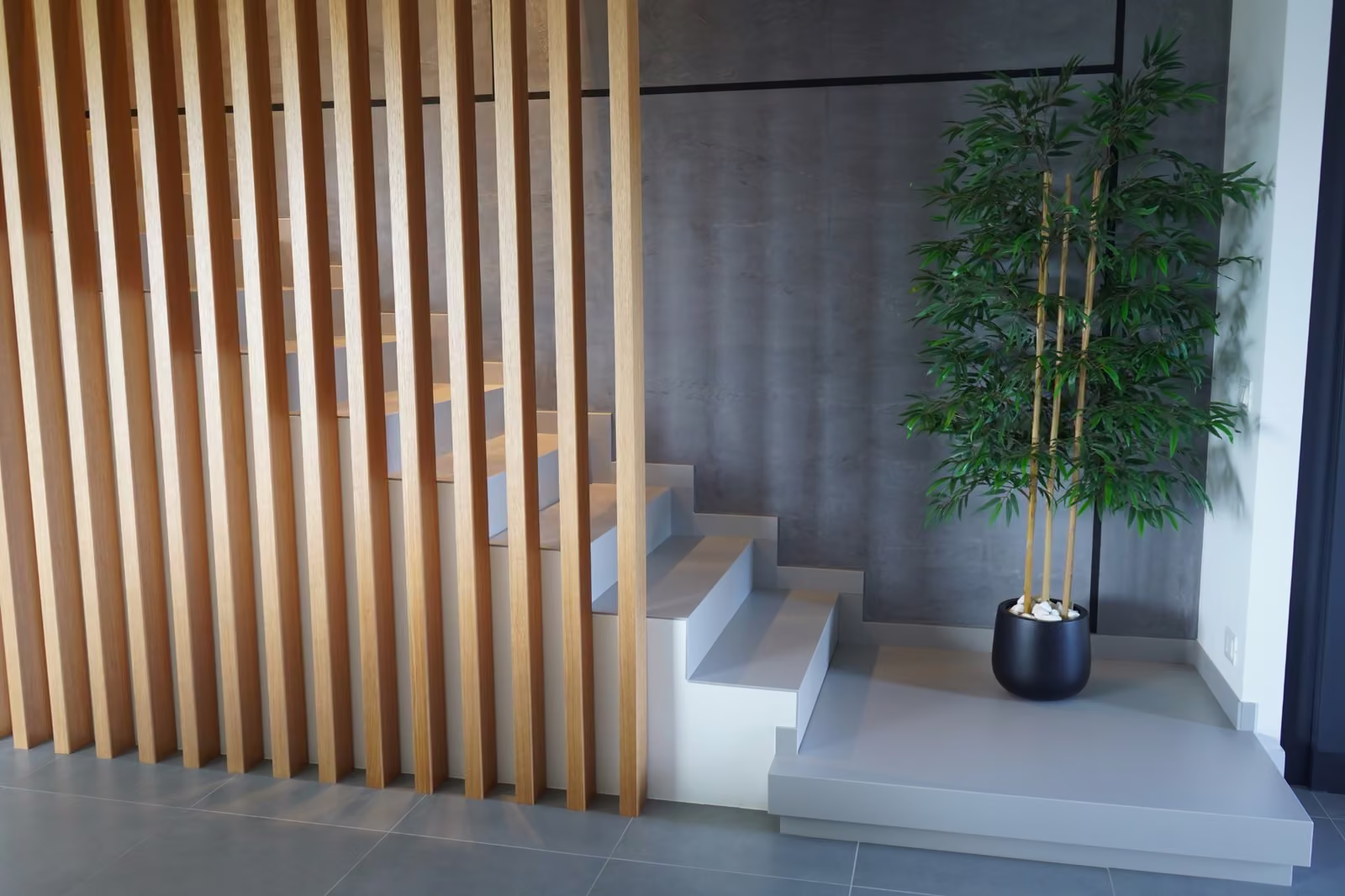 Scala contemporanea con gradini grigi e parete in legno