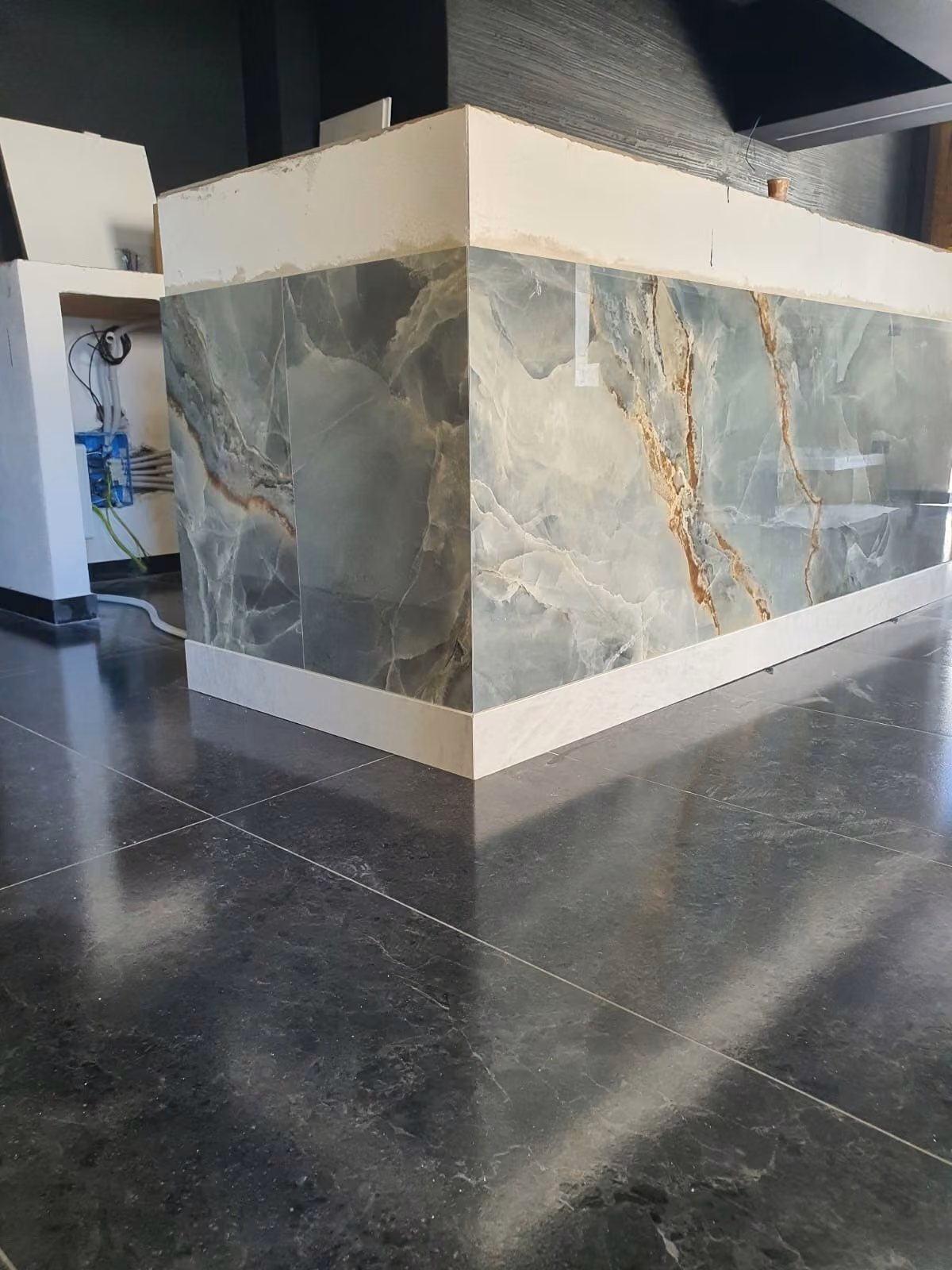 Bancone con rivestimento in pietra venata e bordi chiari